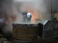 大量の蒸した酒米を、杜氏が機械の中へ入れています。かなりの重労働で、腰が痛くなります。